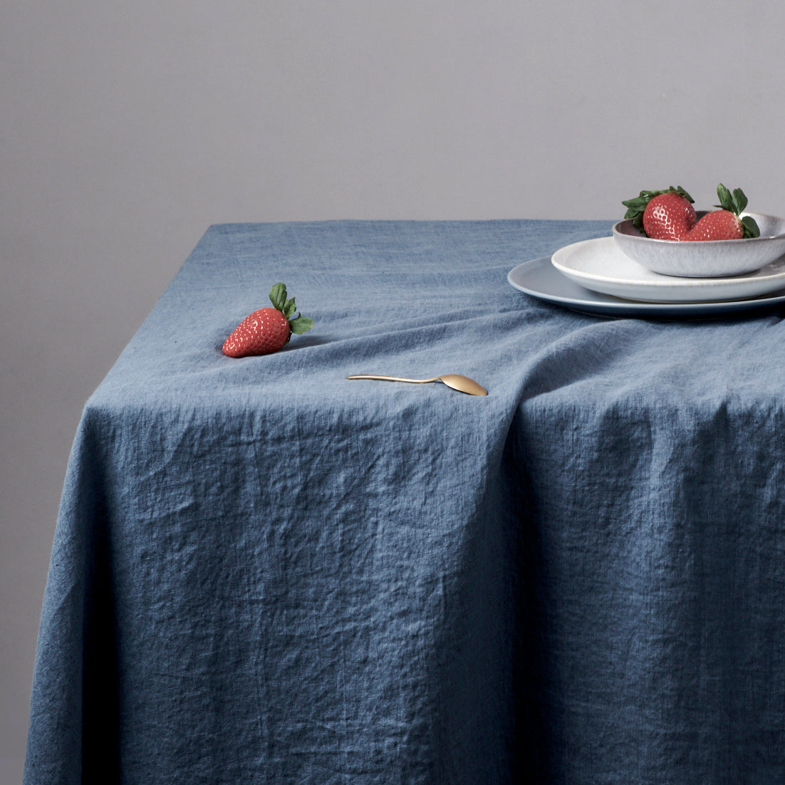 Leinen-Tischdecke Atlantikblau dekoriert mit frischen Erdbeeren und Teller auf einem Tisch.