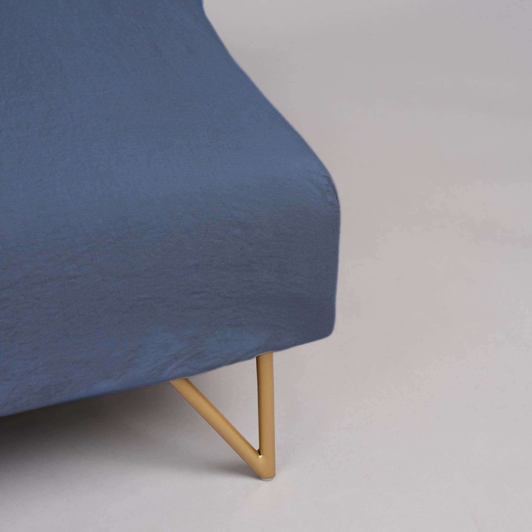 Leinen-Spannbettlaken Atlantikblau auf einer Matratze mit goldenem Gestell, ideal für Boxspring-Matratzen.