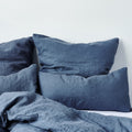 Leinen-Kissenbezug Atlantikblau auf Kissen im gemütlichen Schlafzimmer-Design.