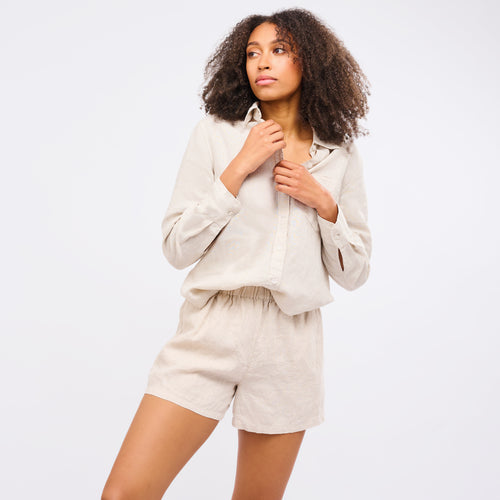 Leinen Shorts Damen Sand in beige mit lockigem Haar und Hemd für Sommerlook.