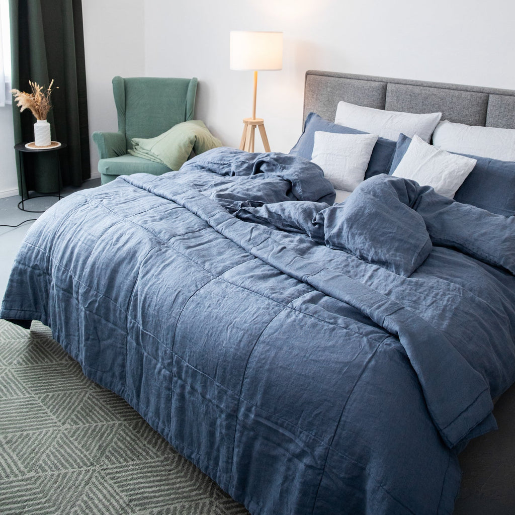 Gesteppte Tagesdecke aus Leinen in Atlantikblau auf einem Bett in modernem Schlafzimmer, stilvoll und bequem.