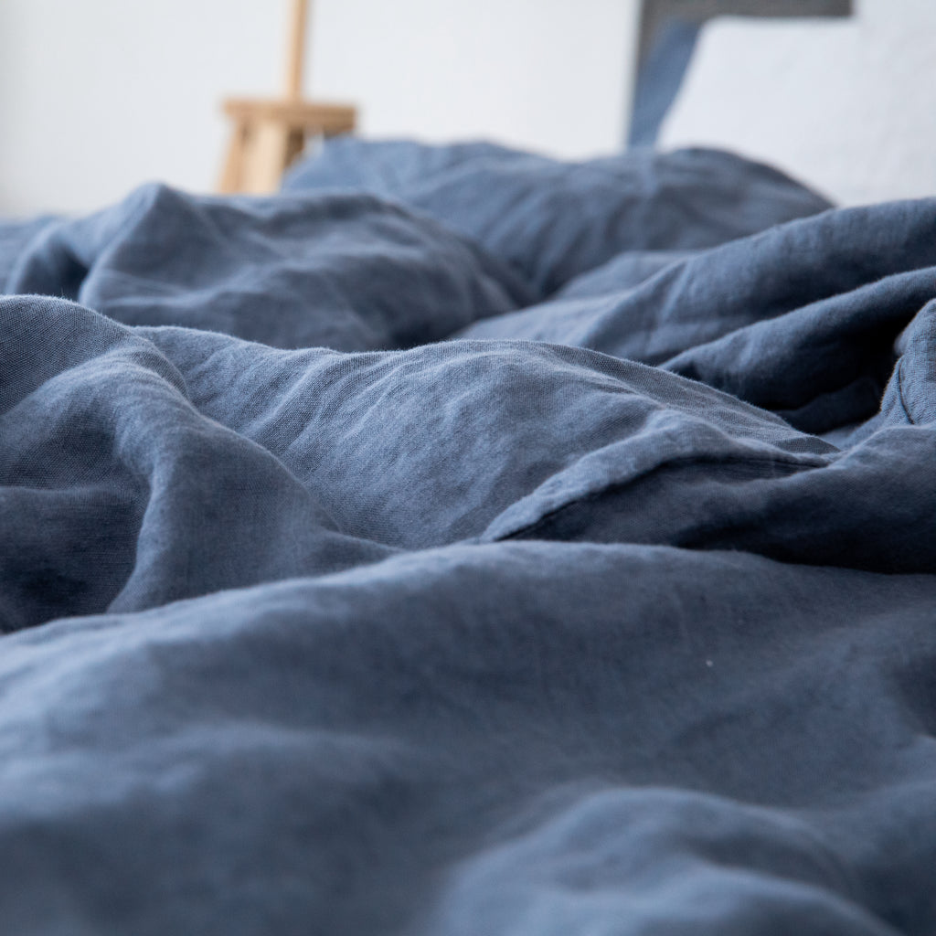Leinen-Deckenbezug Atlantikblau auf einem Bett, natürliches Blau aus 100% Leinen für eine entspannte Schlafzimmeratmosphäre.