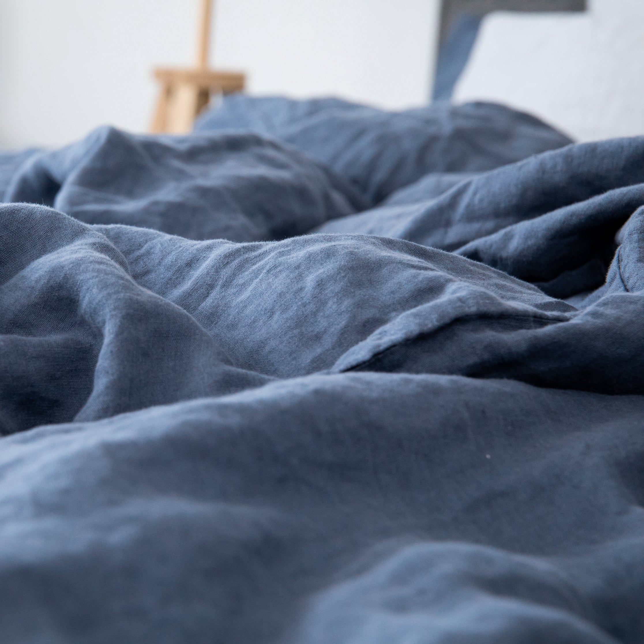 Leinen-Deckenbezug Atlantikblau auf einem Bett, natürliches Blau aus 100% Leinen für eine entspannte Schlafzimmeratmosphäre.