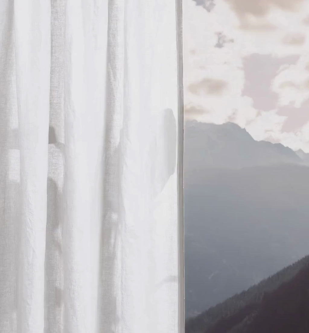 Leinen-Vorhang Alpinweiß, 2 Stück zeigt einen eleganten, lichtdurchlässigen Vorhang vor einer Berglandschaft.